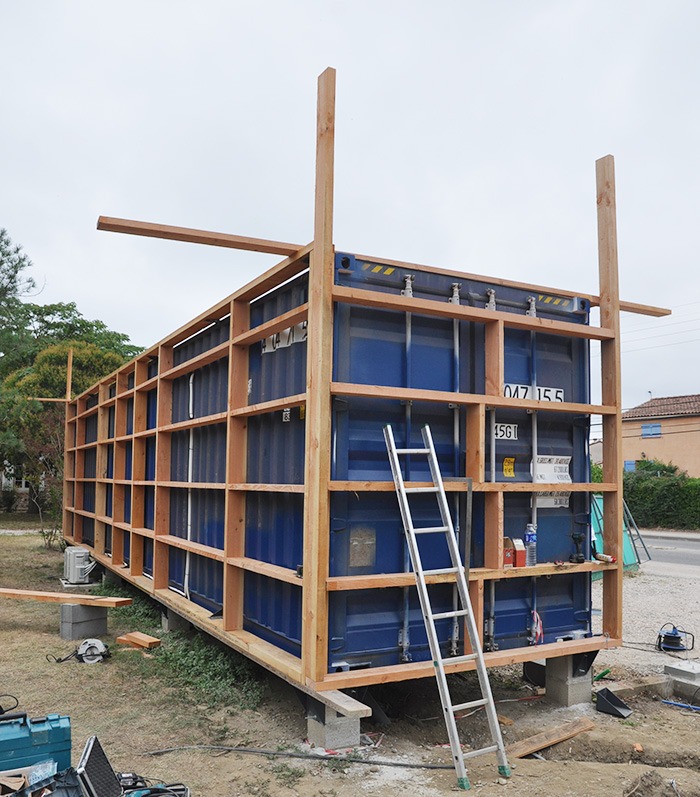 Photographie de chantier, contener maritime habillé d'une ossature en bois.