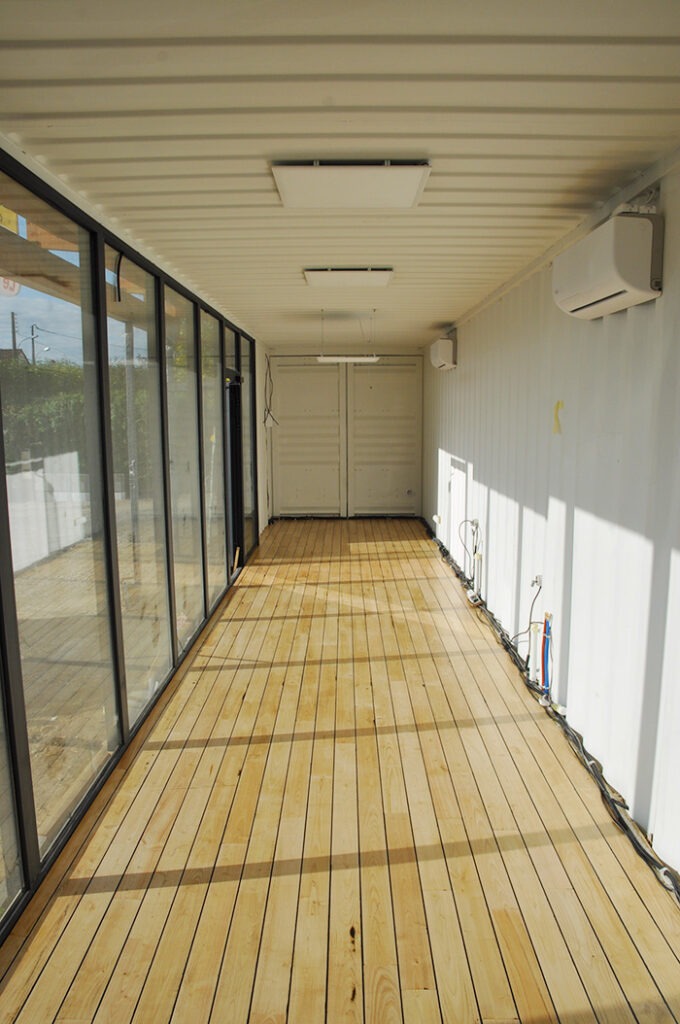 Parquet pont de bateau réalisé à l'intérieur du contener maritime, avec grande vitrine.