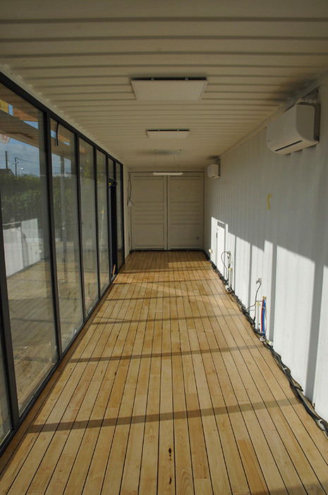 Parquet pont de bateau réalisé à l'intérieur d'un container maritime, avec grande vitrine, pour la constitution d'un salon de coiffure design.