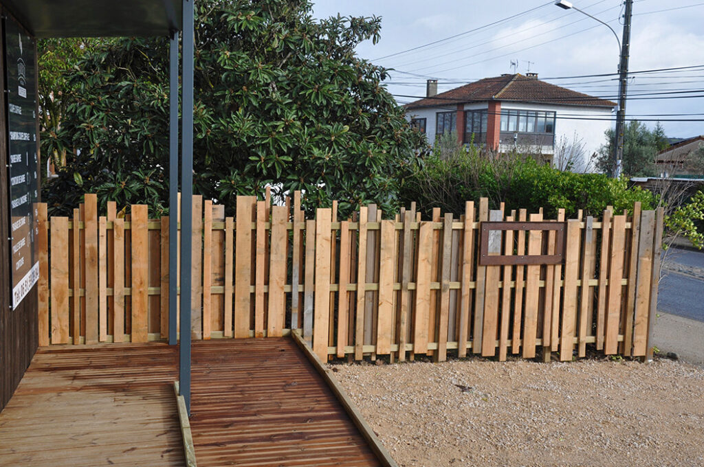 Barrière en bois formée de planches de toutes tailles et de toutes largeurs, associée à un espace commercial design.