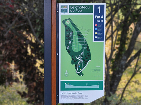 Plan d'un parcours de golf sous la forme d'un panneau disposé en drapeau sur un mât design associant bois et métal.