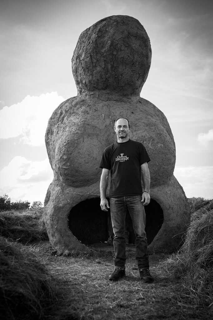 Photographie noir et blanc de Alexandre Drabzak devant son œuvre, la Vénus monumentale.