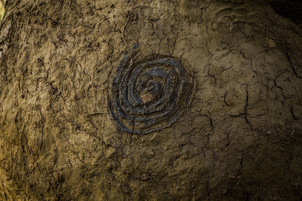 Photographie de détails d'un pétroglyphe en forme de spirale, présent sur le corps de la Vénus monumentale, créée à l'occasion de l'événement l'homme sauvage 2024 par Alexandre Drabzak.