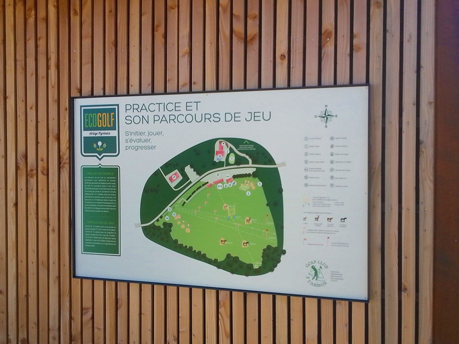 Panneau plan d'un "practice" avec un discret cadre de métal, installé sur un mur en bois.