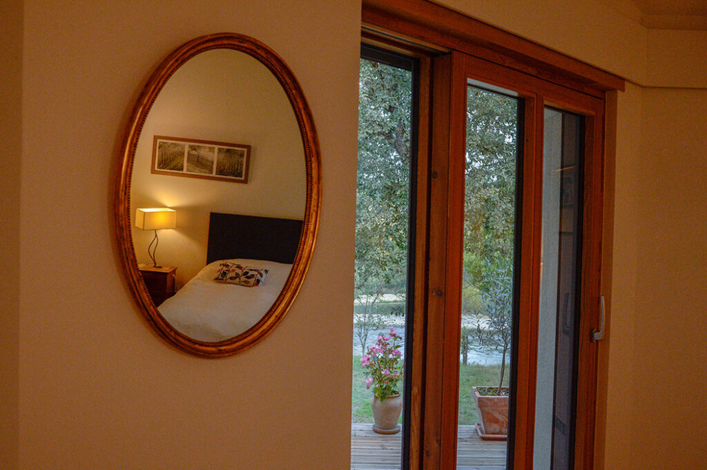 Perspective de la vue à travers la baie vitrée coulissante de la chambre principale, avec miroir.