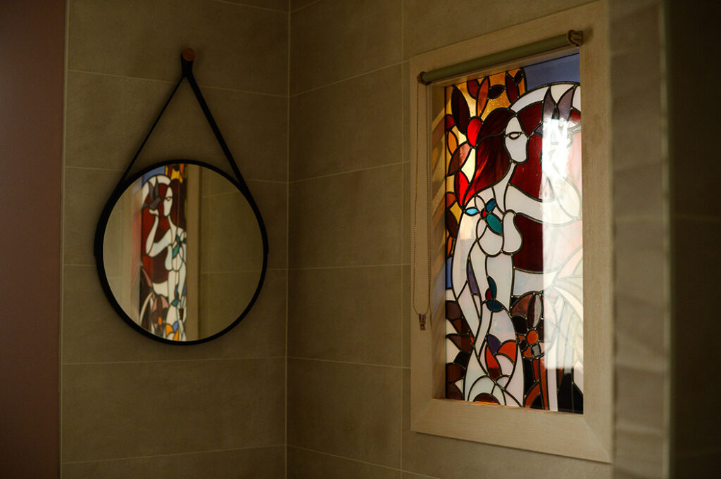 Photographie de vitrail et miroir dans la salle de bain.