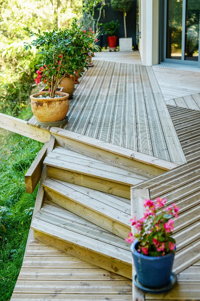 Photographie de la terrasse en bois, escalier dissymétrique.
