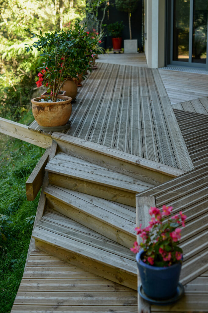 Photographie de la terrasse en bois, escalier dissymétrique.
