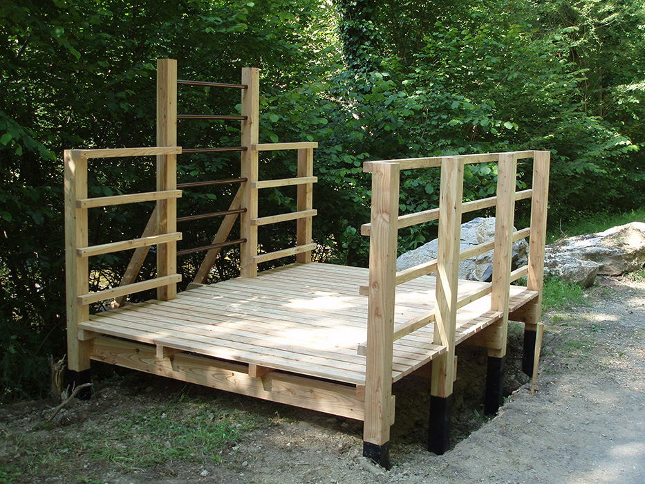 Agrès en bois destiné aux étirement, constitué d'une plateforme, de barrière et de barre en acier. Dispositif imaginé, conçu et réalisé par Alexandre Drabzak, et appartenant à un ensemble constituant un parcours sportifs de plein nature.