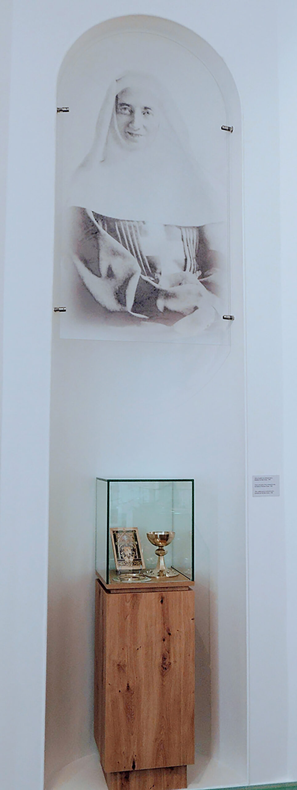 Portrait sur panneau transparent de Mère Thérèse-Emmanuel, et vitrine avec objets liturgiques.