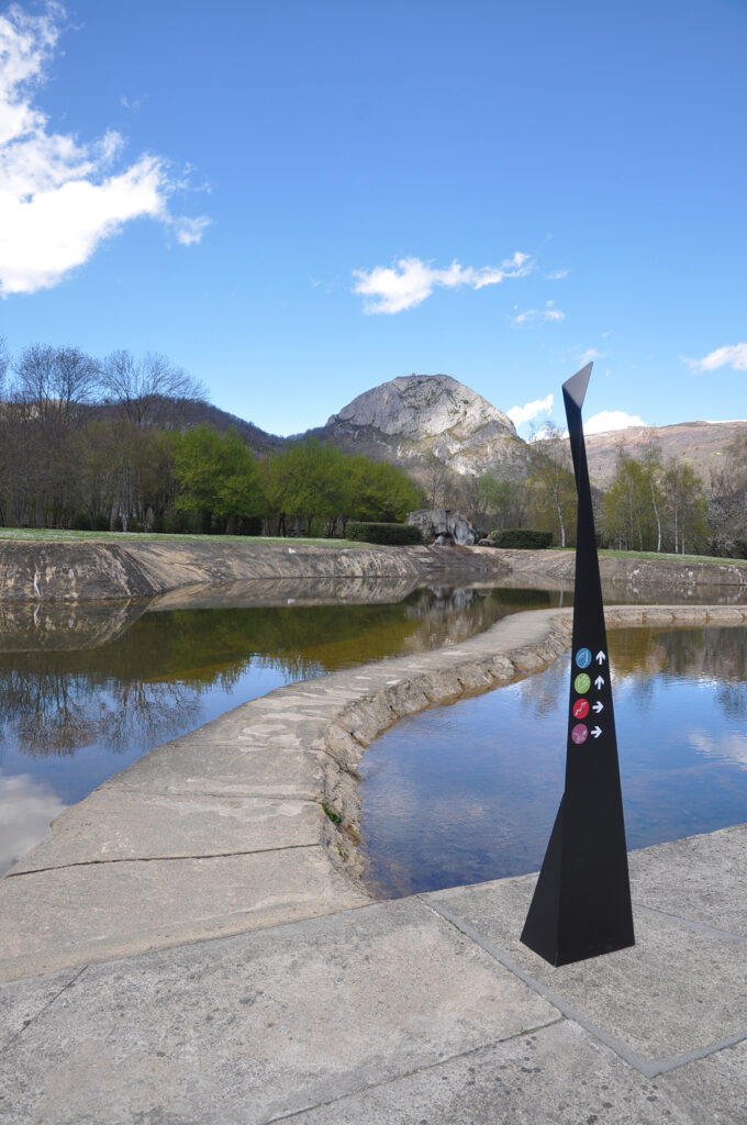 Photographie d'un totem design, en acier plié et thermolaqué, en cohérence avec l'architecture contemporaine marquée du site. Le principe design n'est pas sans rappeler les origamis. Celui-ci, destiné à l'orientation, comprend des symboles directionnels.