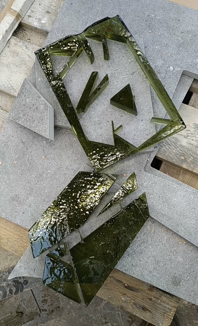 Formes et contre-forme (ou pièces et dépouille) d'un carreau de vitrail vert après découpe au jet d'eau.