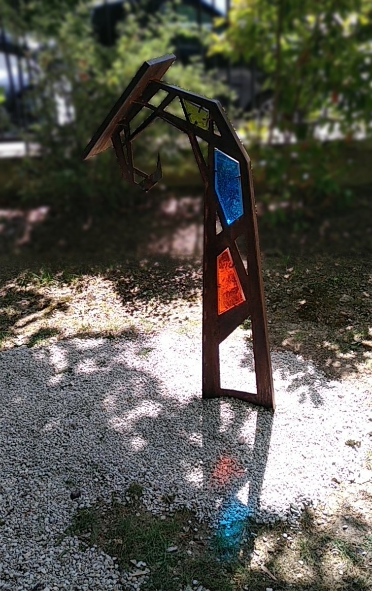 Photographie d'un lutrin à contre jour et des jeux de lumières dit d'"ombre colorée" permis par des vitraux bleu et rouge. Design et concept par Alexandre Drabzak.