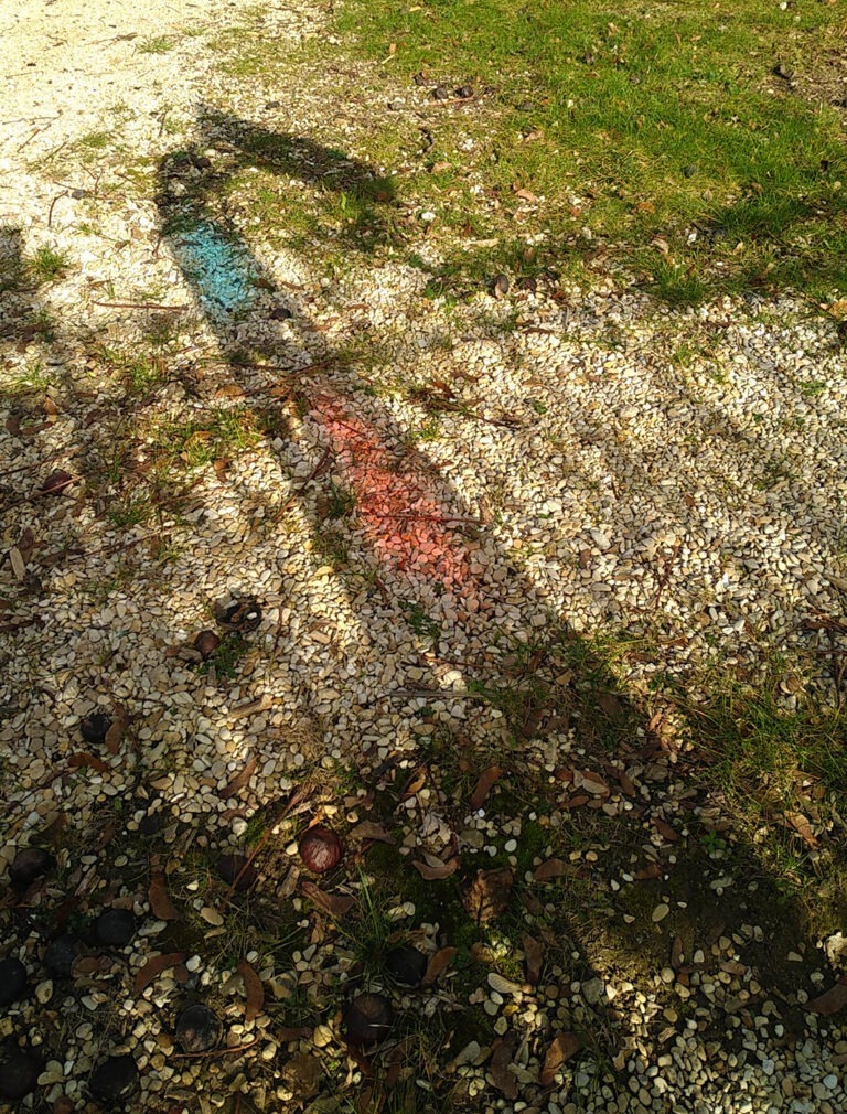 Photographie de l'ombre au sol d'un lutrin, montrant le concept dit d'"ombre colorée" permis par des vitraux bleu et rouge. Design et concept par Alexandre Drabzak.