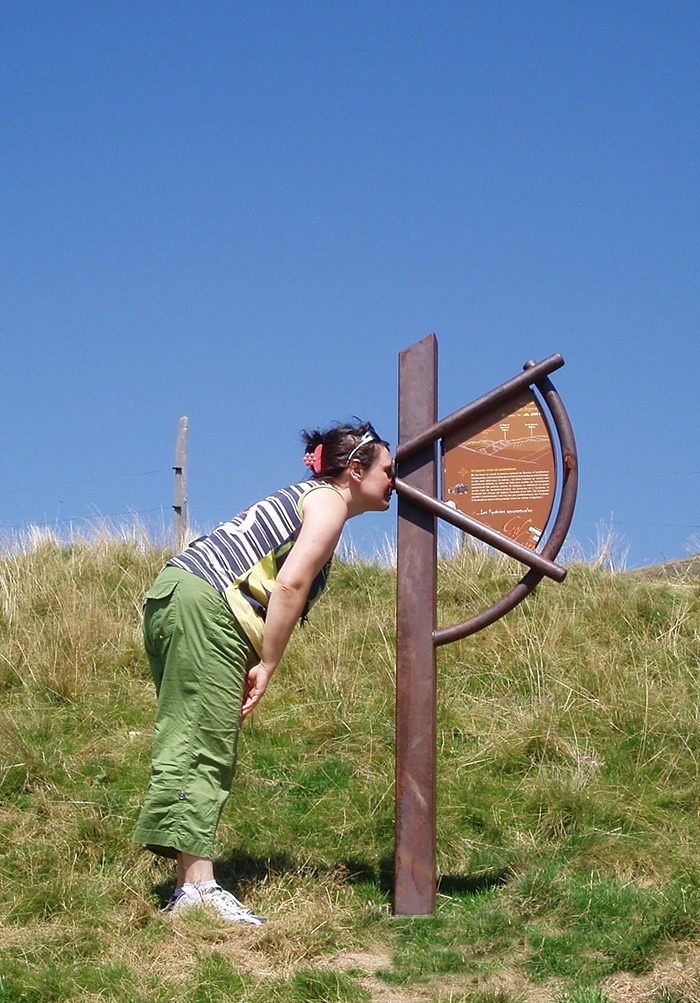 Photographie d'une personne utilisant le Sextant du Plateau de découverte du Col de la Core en Ariège (Pyrénées), pour viser un élément précis du paysage. Concept et design Alexandre Drabzak.