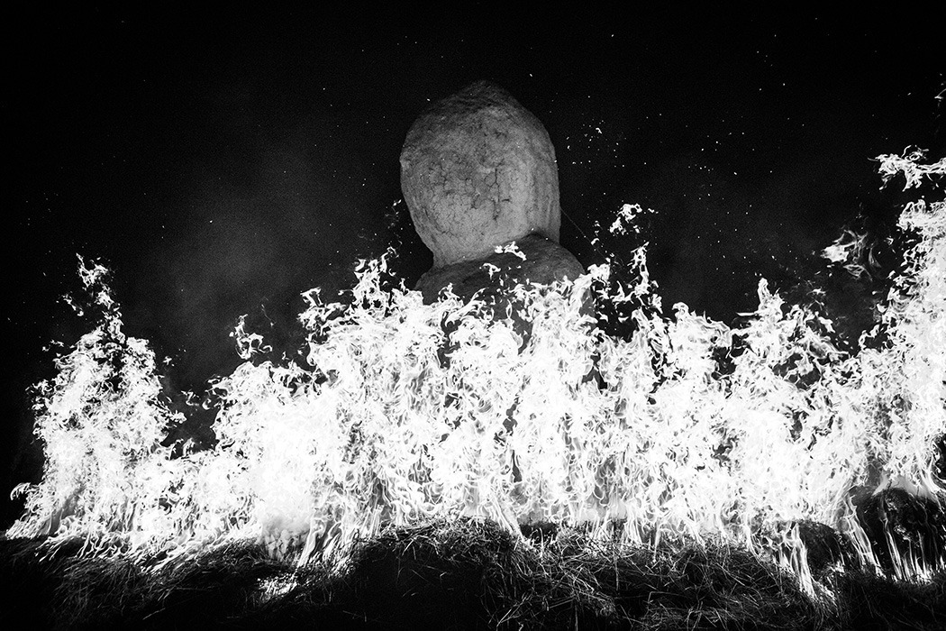 Photographie de nuit en noir et blanc de la Vénus monumentale en terre, entourée de feu, lors de la cérémonie de clôture de l'homme sauvage de 2024. Création Alexandre Drabzak.