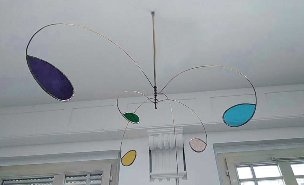 Mobile du musée des Sources, fait de laiton et de vitraux de verre colorés.