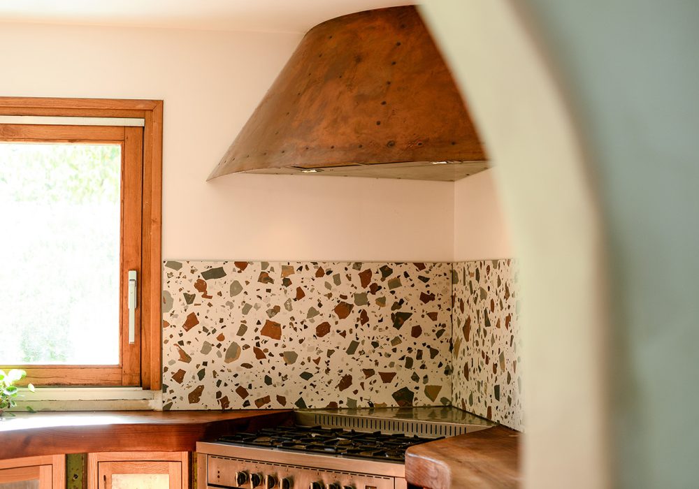 Hotte de cuisine design de style Steampunk, fait d'un manteau de cuivre avec des lignes de cous de cuivre visible. Le dessous de la hotte est en zinc.